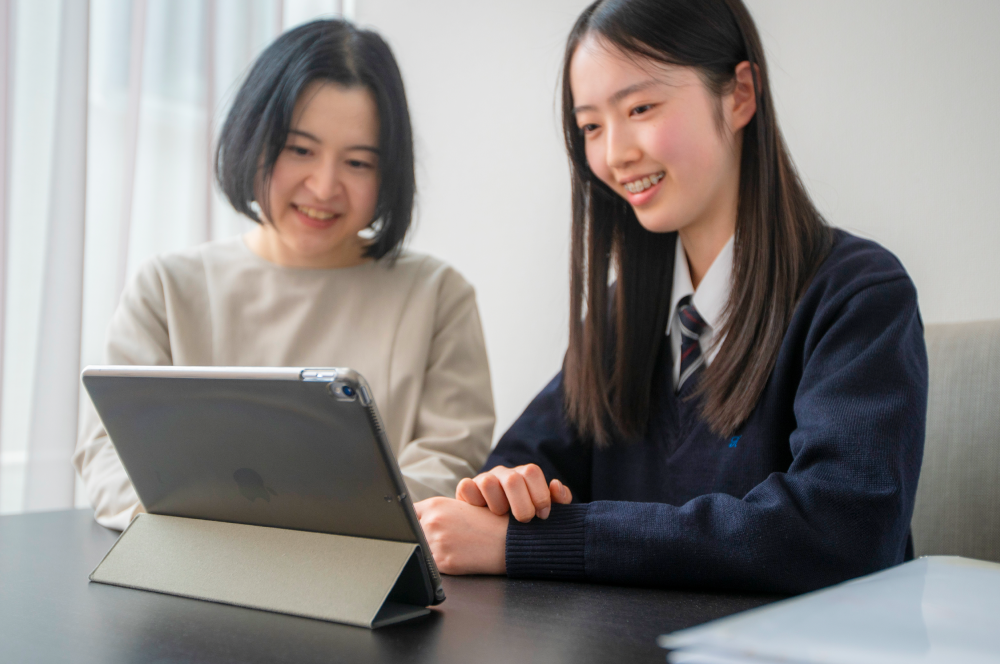 年3回の個別面談 タブレットを使って親子と相談する様子